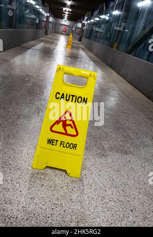 Warning sign UK; Caution wet floor sign, Cambridge North railway station, Cambridge UK Stock Photo
