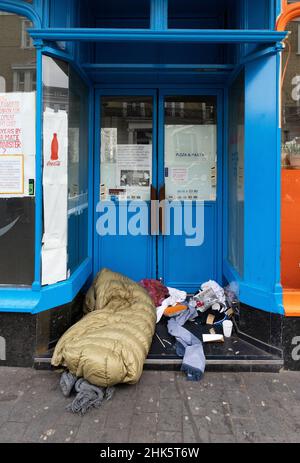 Homeless UK; a person sleeping rough in a doorway, South Kensington, London UK; homelessness London Britain due to Poverty UK.