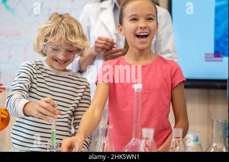 Rejoicing girl near table in chemistry class Stock Photo