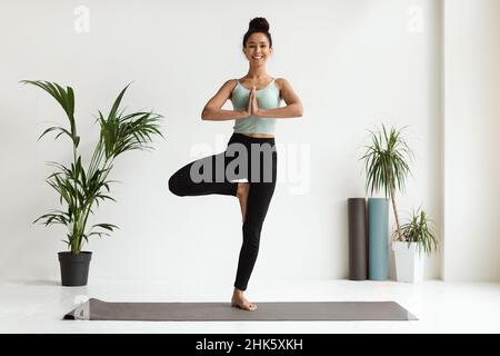 Life Balance. Young Beautiful Woman Practicing Yoga, Doing Tree Pose Stock Photo