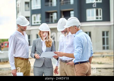 Concentrated professional female inspector checking project documentation Stock Photo