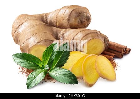 Giner root next to pile of cinnamon sticks, mint leaves and ground cinnamon isolated Stock Photo