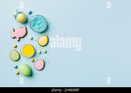 holiday preparation Multi colors Easter eggs with cookies on colored background . Pastel color Easter eggs. holiday concept with copy space. Stock Photo
