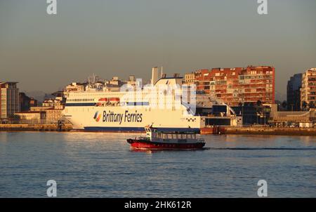 A Regina Ferry boat leaving in the bay of Santander Cantabria Spain with the new Salamanca Brittany Ferries ship in morning winter sunlight Stock Photo