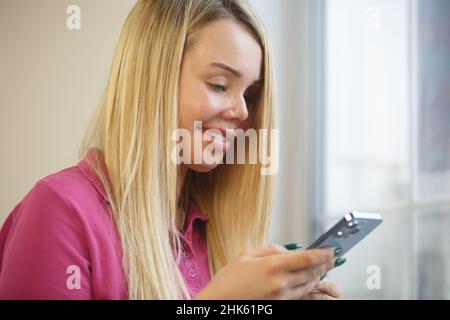 Injured woman with scar on face using mobile phone for communication. Domestic violence survivor with facial scars typing message in social media app Stock Photo