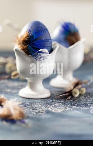 Dyed Easter eggs with marble stone effect painted with natural dye carcade tea from hibiscus flowers on old wooden background with branches of willow Stock Photo