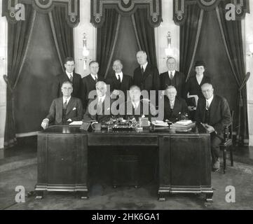 1933 - President Franklin D. Roosevelt (center) and his 1933 cabinet. Seated from left to right: George H. Dern, Sec. of War; Cordell Hull, Sec of State; Roosevelt; W.H. Woodin, Sec of Treasury; Homer S. Cummings, Attorney General. Back Row left to right:  Henry A. Wallace, Sec. of Agriculture; Harold L. Ickes, Sec of Interior; C.A. Swanson, Sec of Navy; James A. Farley, Postmaster General; D.C. Roper, Sec. of Commerce; and Frances Perkins, Sec. of Labor. Stock Photo