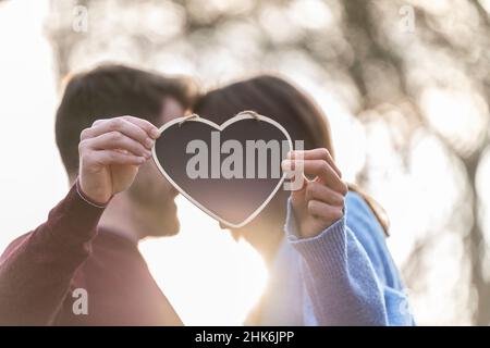 Portrait of a couple holding a heart-shaped blackboard Stock Photo