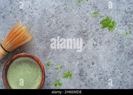 Matcha green tea in a handmade bowl with a bamboo whisk. Stock Photo
