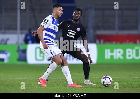 02 February 2022, North Rhine-Westphalia, Duisburg: Soccer: 3rd league matchday 20 MSV Duisburg - VfL Osnabrück at Schauinsland-Reisen Arena. Aziz Bouhaddouz (l) from Duisburg gets to the ball in front of Omar Haktab Traore from Osnabrück. In the 3rd division replay between the two teams, they want to set an example against exclusion by wearing special jerseys. The match was initially interrupted by the referee on December 19 and later abandoned. Osnabrück player Aaron Opoku had previously been subjected to an alleged racist insult by a Duisburg spectator. Photo: Revierfoto/dpa - IMPORTANT NOT Stock Photo