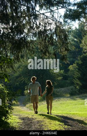 Couple running down path holding hands Stock Photo