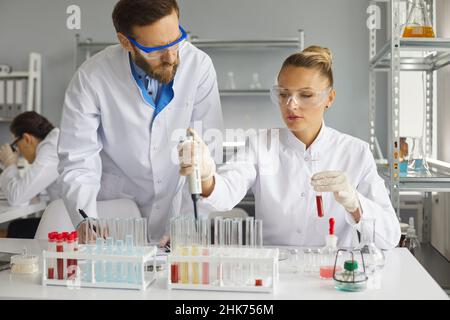 Two scientists working together on the analysis of blood samples while working in the laboratory. Stock Photo