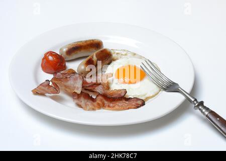 Fried egg, fried bacon and sausages on plate Stock Photo