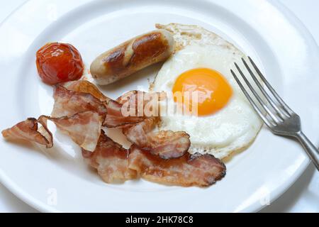 Fried egg, fried bacon and sausages on plate Stock Photo