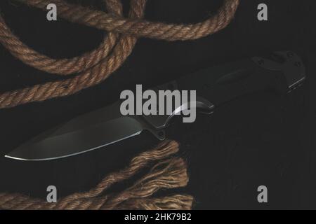 Tactical folding knife for survival, rope and compass, survival kit in  difficult conditions. Stock Photo