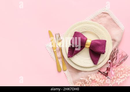 Stylish table setting with flowers on pink background Stock Photo
