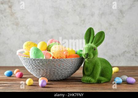 Easter bunny and basket with painted eggs on grunge background Stock Photo