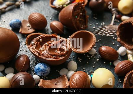 Easter eggs with chocolate paste and candies on dark background, closeup Stock Photo