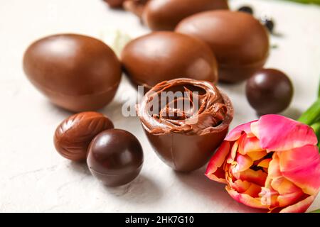 Easter egg with chocolate paste and flower on light background, closeup Stock Photo