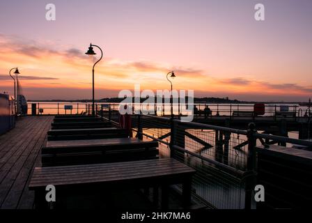 A beautiful sunset over the historic, victorian, wooden Ha'penny pier in Harwich, North Essex, UK.  The town of Shotley can be seen across the river. Stock Photo