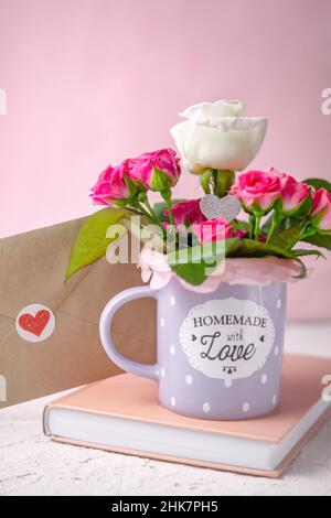 Valentines day greeting card with book, love envelope and roses in the mug Stock Photo