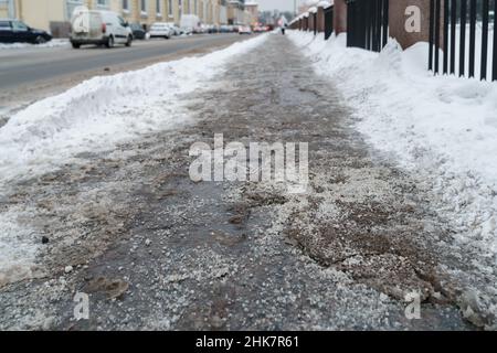 Closeup view of technical salt grains on icy sidewalk surface in ...