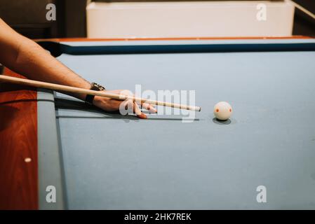 The man is playing billiards. Score the ball into the pocket. Gambler ...