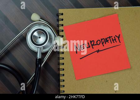 Neuropathy write on sticky notes isolated on Wooden Table. Stock Photo