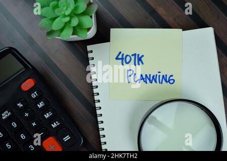 401K Planning write on sticky notes isolated on Wooden Table. Stock Photo