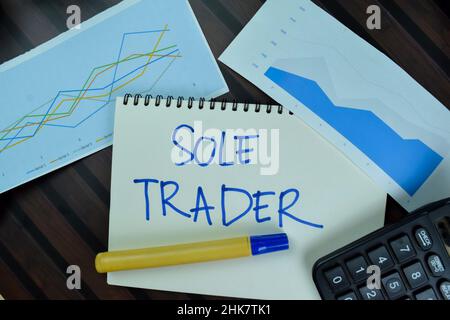 Sole Trader write on a book isolated on Wooden Table. Stock Photo