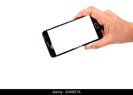 male hand holding cellphone black smartphone in horizontal position filming or photographing something , isolated white background, empty screen for m Stock Photo