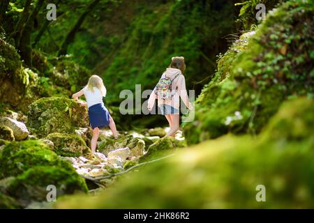 Young girls hiking in Botro ai Buchi del Diavolo, rocky gorge hiking trail, leading along dried up river. Beautiful footpath extending into the woods Stock Photo