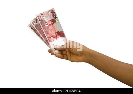 Fair hand holding 3D rendered 100000 Indonesian rupiah notes isolated on white background Stock Photo