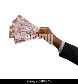 Black hand with suit holding 3D rendered Ghanaian cedi notes isolated on white background Stock Photo