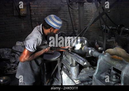 FEBRUARY 02,2022,DHAKA,BANGLADESH- Workers make utensils in an unhealthy environment at an aluminium factory in Dhaka's Kamrangirchar is home to a num Stock Photo