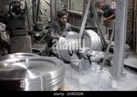 FEBRUARY 02,2022,DHAKA,BANGLADESH- Workers make utensils in an unhealthy environment at an aluminium factory in Dhaka's Kamrangirchar is home to a num Stock Photo