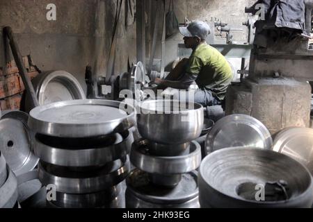 FEBRUARY 02,2022,DHAKA,BANGLADESH- Workers make utensils in an unhealthy environment at an aluminium factory in Dhaka's Kamrangirchar is home to a num Stock Photo