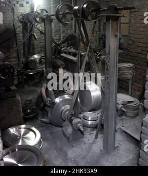 FEBRUARY 02,2022,DHAKA,BANGLADESH- Workers make utensils in an unhealthy environment at an aluminium factory in Dhaka's Kamrangirchar is home to a num Stock Photo