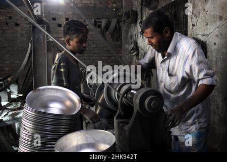 FEBRUARY 02,2022,DHAKA,BANGLADESH- Workers make utensils in an unhealthy environment at an aluminium factory in Dhaka's Kamrangirchar is home to a num Stock Photo