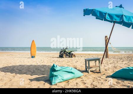 Vintage green ATV on the sandy beach. Quad ATV all terrain vehicle parked on beach, Motor bikes ready for action with summer sun flaring on bright day Stock Photo