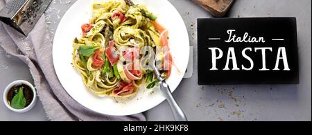 Pasta with asparagus and prosciutto on gray background. Traditional Italian Food concept. Top view, flat lay, panorama Stock Photo