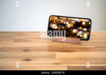 Smartphone standing on the table with scrren mocked up. video watching concept. Stock Photo