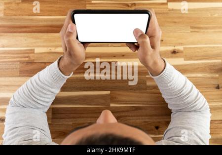 Top view photo of man watching video  or playing mobile game. Screen mockup. Stock Photo