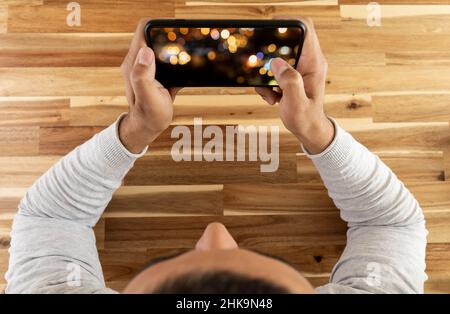 Top view photo of man watching video  or playing mobile game. Screen mockup. Stock Photo