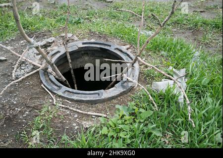 Sewer with an open manhole cover. Stock Photo