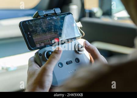 Operator controls drone by smartphone in hand. Stock Photo