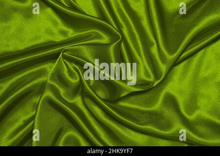 Texture of crumpled green olive satin fabric, beautiful pattern, top view. Stock Photo