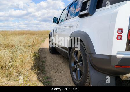 Russia, Rostovskaya oblast, 2021 June 09: Modern new SUV car Land Rover Defender, test drive on dirty road. Offroad 4x4 driving in wild. Stock Photo
