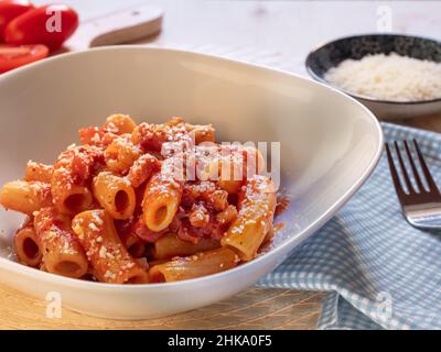 dish of Amatriciana. Italian pasta recipe with tomato sauce, bacon and parmesan on top.Tomato sauce macaroni. Italian food. carb diet, top view Stock Photo