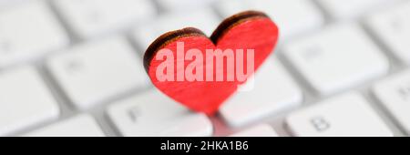 Small red heart on computer keyboard closeup Stock Photo